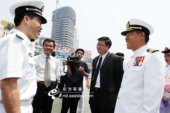 海军上海基地副参谋长汪立平上校在码头与"吉打"号舰长陈朋荣海军中校
