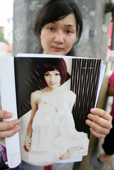 “人造美女”向记者展示医院的宣传广告。 图/记者 金振强 摄