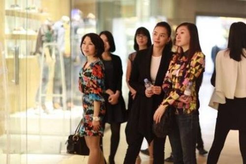 来宾们在店铺外欣赏模特展示新品