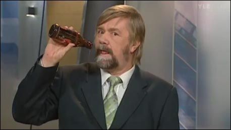 　　威斯卡拿起啤酒正准备喝时，发现镜头在拍他，马上放下酒瓶若无其事继续播报新闻。(图片截自芬兰电视台)