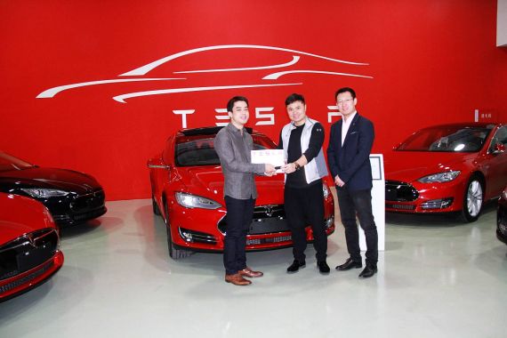 特斯拉中国区公共充电业务负责人王昊、中国区交付团队负责人Jeff Liu为中国首位P85D车主王振飞交付车辆