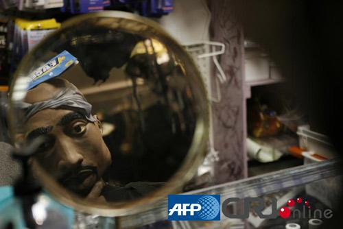 名顾客在镜子前试戴各种搞怪面具。图片来源：(AFP/国际在线)