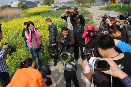 大家争先恐后拍搞怪小男娃(曹风增摄)