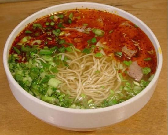 6.兰州拉面 兰州牛肉拉面,又称兰州清汤牛肉面,是甘肃省兰州地区的风味小吃。传说起源于唐代,它以汤镜者清,肉烂者香,面细者精的独特风味和一清二白三红四绿五黄,一清(汤清)、二白(萝卜白)、三红(辣椒油红)、四绿(香菜、蒜苗绿)、五黄(面条黄亮),赢得了国内乃至全世界顾客的好评。