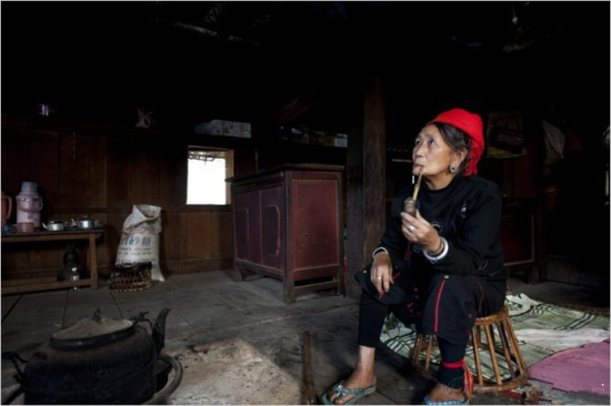 寨子里的女人叼着烟袋(图片来源：@云南旅游)