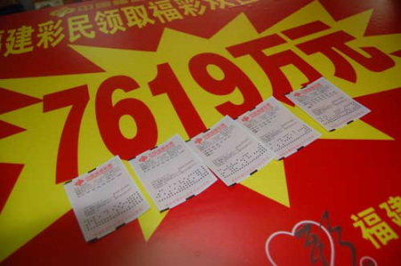 中得7619万巨奖的5张彩票静静地躺在宣传牌上。