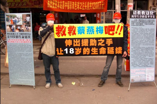 网友来到开出1200万大奖的投注站，拉横幅呼吁捐助。