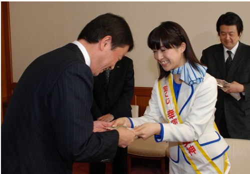 幸运女神冈崎小姐将所购买的彩票交给村井知事(日本县的长官)。