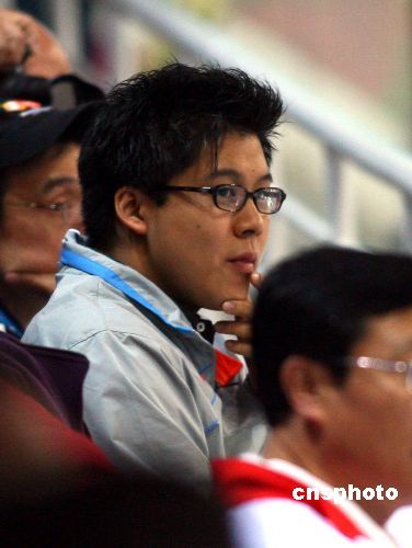 　　多哈亚运会跳水女子双人三米板决赛，中国选手郭晶晶、李婷获得金牌。霍启刚在看台上身穿中国队运动服观看比赛。