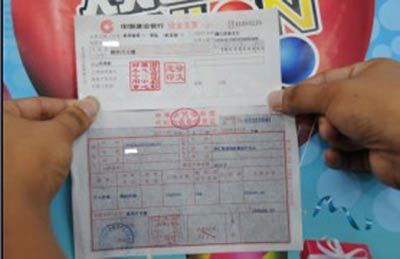 1000万得主小张展示现金支票和纳税凭证