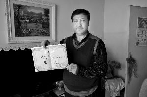 巴力的父亲展示儿子的荣誉证书。