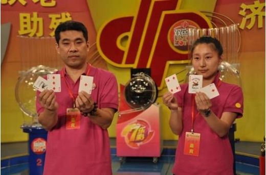 齐晶晶、王兆旭抽出开奖用球，扑克牌大王所压的扑克牌号码为当晚摇奖用球。