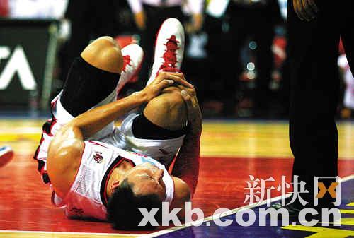 易建联右膝被撞躺倒在地，右手紧紧握拳，表情很痛苦。 新快报记者 黎湛均/摄 
