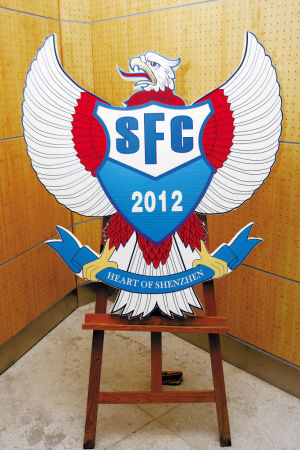 　　名博队徽以大鹏为雏形，红色代表激情，蓝色代表深圳精神。不设计成盾牌或其他形式，是寓意着大鹏能展翅高飞，代表深圳走向国际舞台。球衣红色为主代表热情，蓝色的领子象征着深圳的海洋精神。 本版图片由深圳晚报记者 黎晓斌摄