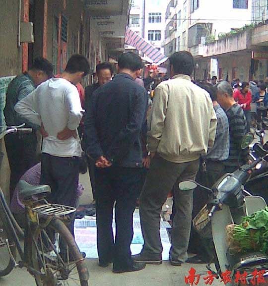 在廉江某菜市场，一个地下“六合彩”卖号摊位前围着不少人