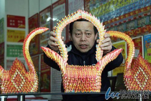 老站主展示废彩票做成的艺术品，图片来自聊城新闻网
