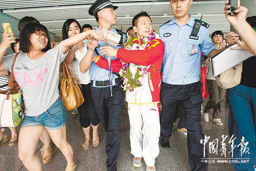 8月9日，北京，刚下飞机的奥运会体操男团冠军陈一冰面对粉丝们的签名请求，忙得应接不暇。