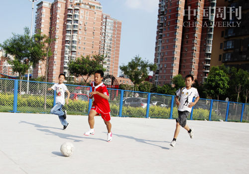 　　华源一里小区内水泥地上的垃圾已被清空，涂子月和伙伴们目前经常走一公里左右来这里踢球。但水泥地踢球易受伤，曹炎(右一)曾在此摔倒并骨折。摄影 商华鸽
