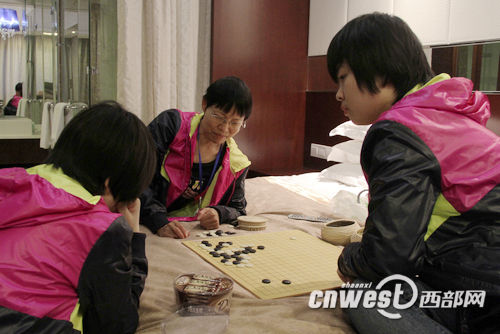 孔祥明在酒店房间为陕西众源围棋队两名小棋手复盘指导。