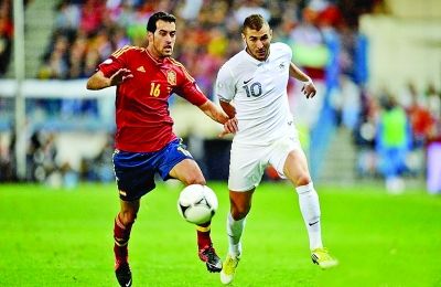 效力于皇马的法国国脚本泽马（白衣），将再度对垒巴萨的西班牙中场布斯克茨（红衣）