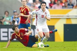 6月20日的联合会杯，西班牙球员马丁内斯（左下）与塔希提队球员张秀（右）在比赛中拼抢。 新华社