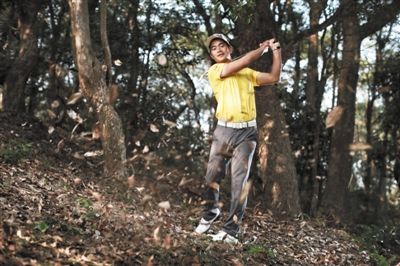 梁文冲用球杆击打树叶。作为中国一哥，他的表现丝毫不逊这落叶缤纷的美景。