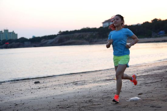 周晓欣沿海滩跑步。