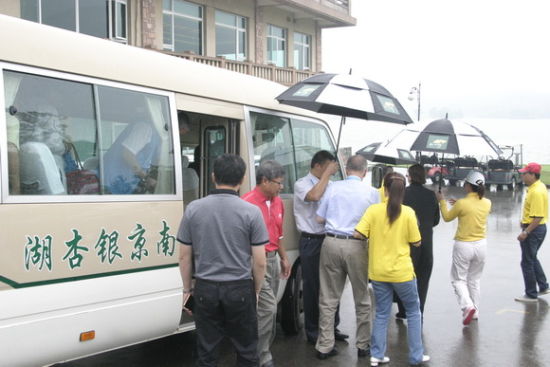 林铭田董事长(左二)与罗格先生冒雨走向球场。