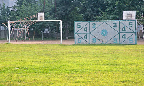 平壤龙威中学运动场，足球场有天然草皮和射门墙 