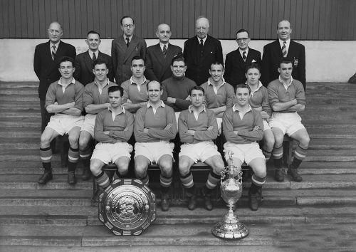 1952年，曼联球员和工作人员与联赛冠军和慈善盾冠军奖杯合影