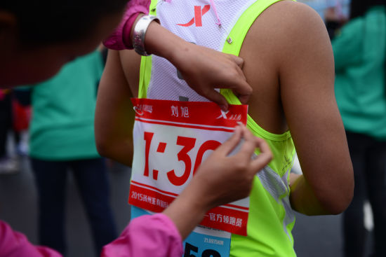 领到兔子的专属“身份证”——标示着完赛时间的气球后，刘旭又别上了兔子专属的号码布。
