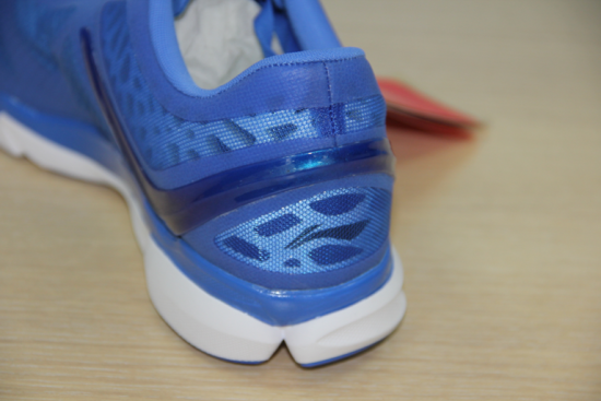 鞋子的后部区域，可以更清晰的看到足跟部的网布内大大小小的不规则镂空孔。