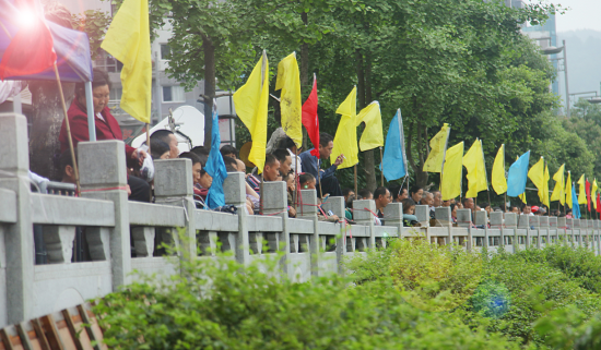 在岸上等待参赛亲友返回的人们，组成了最强大的啦啦队阵容。