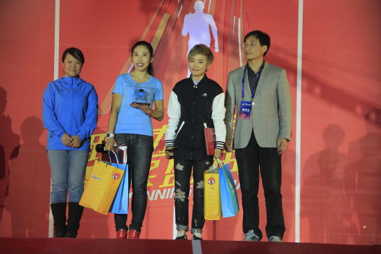 评委会委员、中国田径协会马拉松委员会委员顾斌先生（右一）和评委会委员、户外探险杂志主编何亦红女士（左一）登台为著名音乐人许飞（右二）、跑者女神曲丽杰（左二）颁发了中国领跑英雄奖杯和奖品。