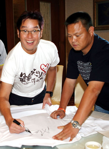 图文星战前国脚谢育新vs谭咏麟挥毫签下大名