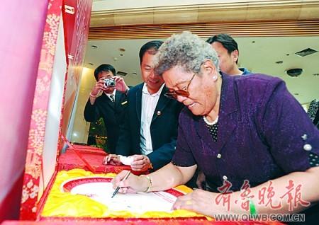 潘多在本报特别制作的“功勋盘”上签名。