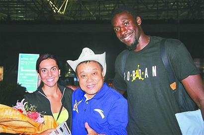 亨特(右一)在济南机场与女友(左一)以及前来欢迎他的济南球迷代表王大全合影 记者谢永亮 摄