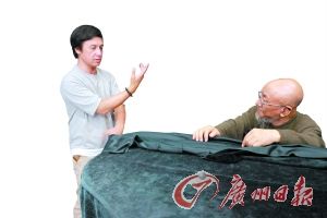 岑兆伟(左)为李正天讲解咏春拳的攻防要领。广州日报记者 施绍宗 摄